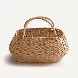Rustic rattan basket handmade from natural fibers offering durable storage for clothes laundry or decorative needs