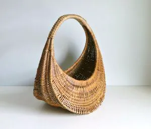 Beautiful handcrafted rattan basket with traditional weaving style for timeless rustic or farmhouse home decor