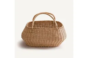 Rustic rattan basket handmade from natural fibers offering durable storage for clothes laundry or decorative needs