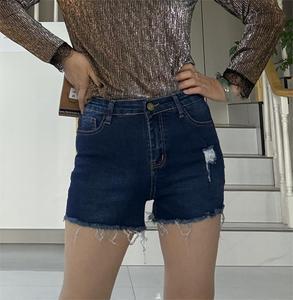 The lady's sexy denim shorts with torn closures and elasticized tight fit - a stylish streetwear look for a woman.