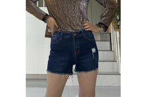The lady's sexy denim shorts with torn closures and elasticized tight fit - a stylish streetwear look for a woman.